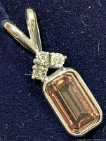 Close-up front view of the pendant showing the rectangular lab-created diamond and three smaller diamonds above it, set in 14K yellow gold.