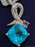 Close-up photo showing the front view of the silver pendant with the large square cushion cut blue quartz and smaller round amethyst set above it.
