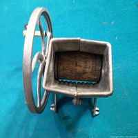 Front view showing rectangular crushing area with missing wooden cylinder and metal teeth.