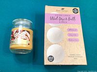 Photo of Plant Therapy 6 pack extra large wool dryer balls packaging and the Frosted Gingerbread scented candle jar.