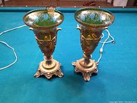 Pair of amber Bohemian glass lamps with ornate brass bases on billiard table