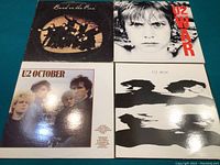 Four vinyl album covers laid out in a 2x2 grid: Band on the Run (top left), War (top right), October (bottom left), and Boy (bottom right). Reflective surfaces indicate very good condition.