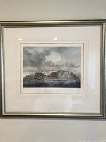 Full view of framed lithograph showing maritime coastal scene with ships and cliffs.