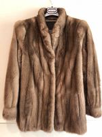 Front view of light brown mink coat-jacket hanging on hanger