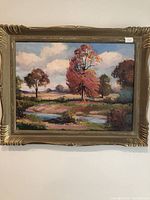 Frontal view of the oil painting showing the landscape scene, frame, and hanging.