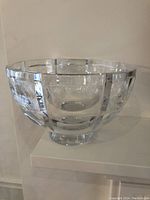 Clear crystal vase with geometric window cut pattern, side view revealing rounded bowl shape on pedestal base.