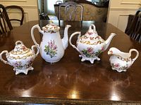 All four pieces displayed on table: coffee pot, teapot, creamer, sugar bowl.