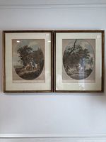 Two framed oval engravings by Francesco Bartolozzi hanging on a wall, showing 'The Benevolent Lady' and 'The Happy Meeting.'