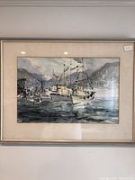 Full view of framed watercolor art showing fishing boats in a harbor with a mountainous background.