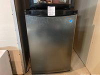 Front view of the Danby mini fridge with stainless steel door and black edges.