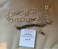 Full view of necklace, charm bracelet and earrings with lot tag