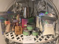 Full kit showing wax bags, pouring pot, tin molds, wicks, stir sticks, and small accessory box arranged on a table.