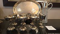 Overview of six Primrose Bacchanalian goblets, two Valero goblets, hammered peacock serving tray, and cut glass decanter