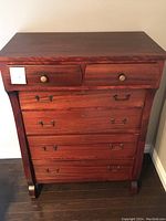 Front view of tall vintage six-drawer wooden dresser showing drawer handles and curved side legs.