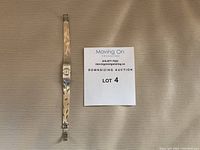 Full view of watch alongside auction lot sign