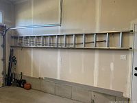 Full view of ladder mounted on garage wall showing overall length and condition
