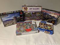 Photo showing all puzzle boxes including National Geographic 3D and multiple Art Gallery 1000-piece puzzles