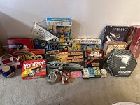 Full collection of assorted games and bingo accessories arranged on floor showing game boxes and bingo paraphernalia