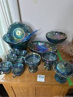 Overview of lot on wooden cabinet: punch bowl, cups, compotes, fruit bowls, platter and candy dish