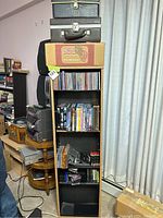 Rotating multimedia rack filled with various media including CDs and VHS tapes.