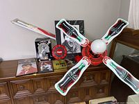 Overall view of the lot including the Coca Cola ceiling fan with bottle graphics, Elvis Presley portrait, clocks, and other memorabilia on a wooden dresser.