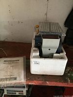 Mastercraft 4x36 Belt/Disc Sander nestled in styrofoam packaging on work surface with instruction manual beside it.