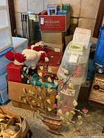 Photo showing stacked boxes with a large plush toy and a decorative metal wall art piece with leaves and flowers in front.