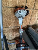 Full view of Stihl FS 38 trimmer leaning against plywood wall