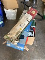 Damaged box of Hank Haney Plane Finder golf practice net and other golf accessories in boxes.