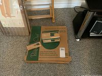 Boxes of the Pampered Chef large round stone and deluxe cheese grater shown on carpet floor.