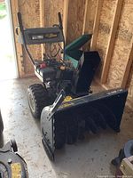 Front and side view showing auger housing, chute and drive wheels