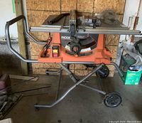 Front view of Ridgid table saw mounted on folding steel stand with wheels