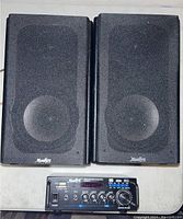 Photo showing the pair of black Monkey speakers alongside the Monkey Watts Continuous Power 2.0 channel audio power amplifier with multiple inputs and control knobs.