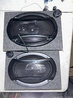 Two Pioneer speakers in carpeted wooden enclosures with protective grills and wiring visible.