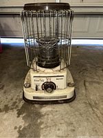 Front angle view of Radiant King TO-450 radiant heater with metal protective cage, control knob, and labels visible.