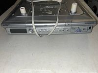 Front view of Sony home audio system showing control panel, CD tray, buttons, and dials.