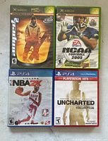 Four video games laid out showing Xbox and PS4 titles.
