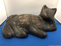 Front angled view of black ceramic cat figurine showing painted designs on the back and facial details
