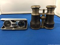 Top view of antique marine field glasses and vintage opera glasses on blue background