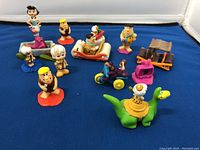 All 13 Flintstones figurines and vehicles displayed.