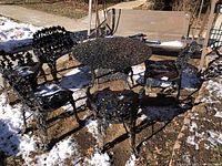 Wide view showing entire set: round table, loveseat bench and four chairs arranged outdoors