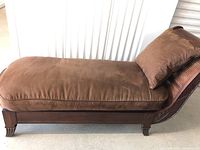 Full left-side view of chaise lounge showing overall shape, cushion, frame and swiveled backrest.