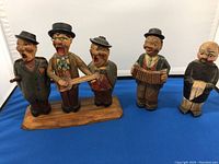 Front view of the full set including the trio on base and separate pair of figures, showing detailed facial expressions and clothing.