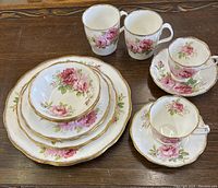Full set of Royal Albert American Beauty bone china dinnerware pieces shown on wood surface.