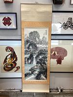 Full view of vertical hanging scroll painting with mountain landscape, waterfall, river, trees and buildings.