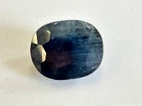 Top view of the loose blue sapphire showing oval shape and faceting.