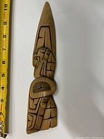 Front view of carved cedar eagle wall plaque with a measuring tape showing about 10 inches in length.