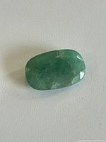 Top view of the emerald gemstone showing its medium green color and natural inclusions.