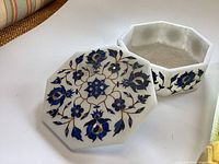 View of the trinket box with lid removed, showing white marble and detailed blue floral inlay on top and sides.