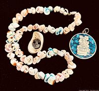 Photo showing Mexican shell bead necklace with irregular natural shells in pastel tones and the Inuit pendant with turquoise inlay